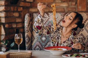 Mulher saboreando uma prato de pasta em um restaurante romano