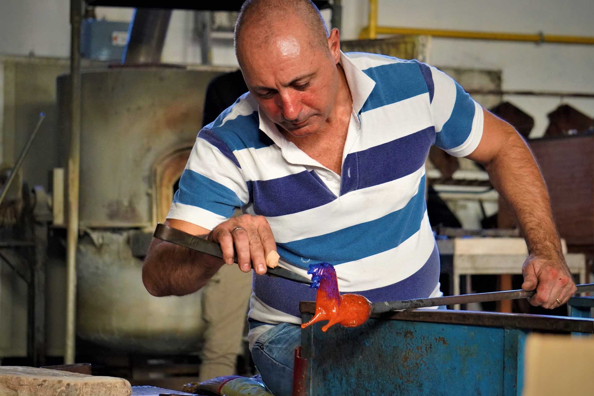 Artesão trabalhando o vidro para produzir os famosos objetos de decoraçao de Murano