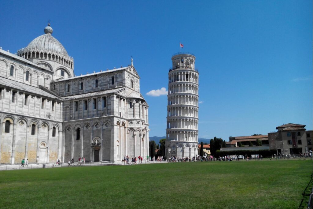Deslumbre-se com o Campo dei Miracoli em Pisa em um dia ensolarado. Turistas ansiosos preparam-se para subir na icônica Torre de Pisa
